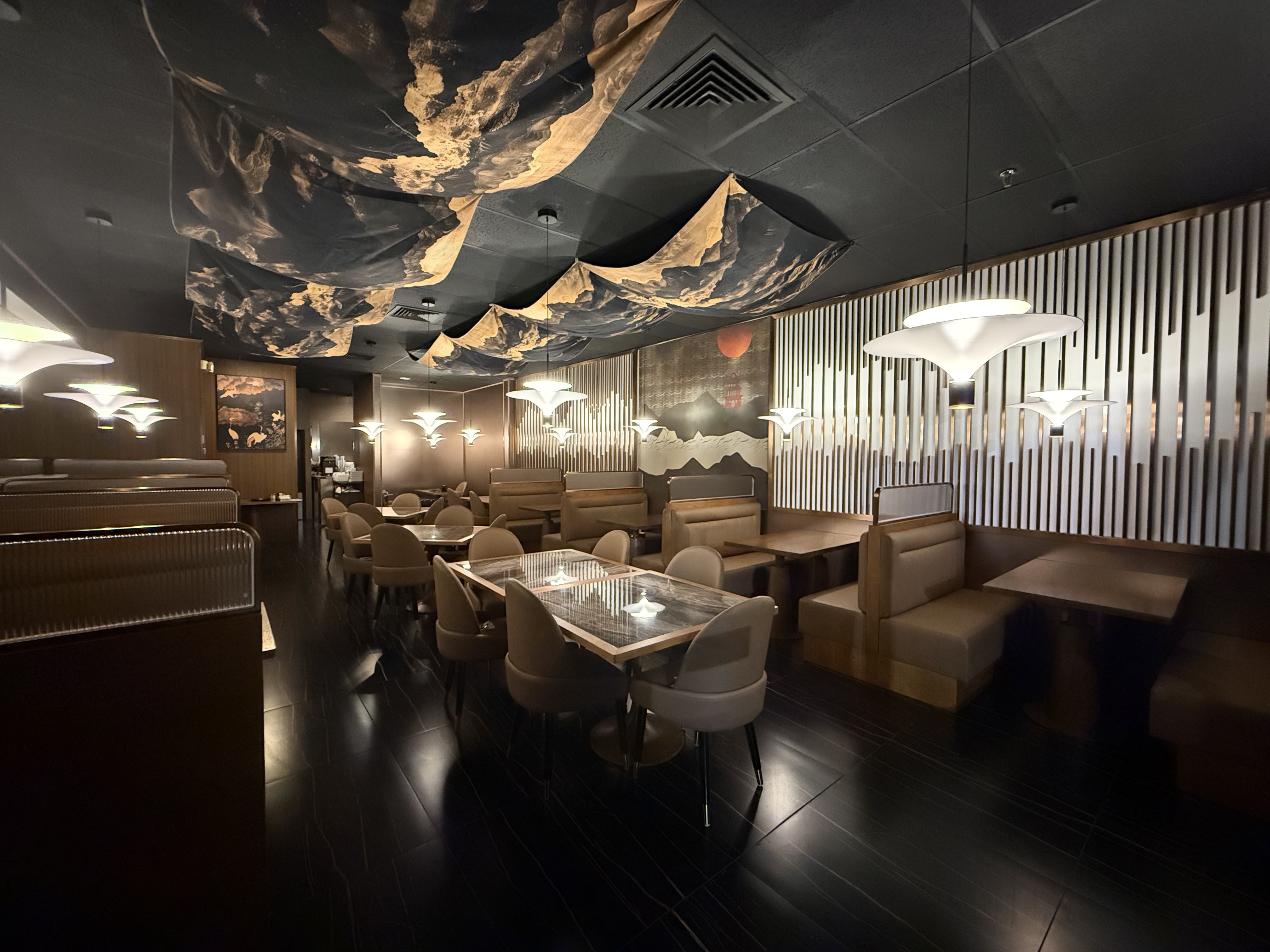 Warm wood slat wall and dining room at Bao & Blade