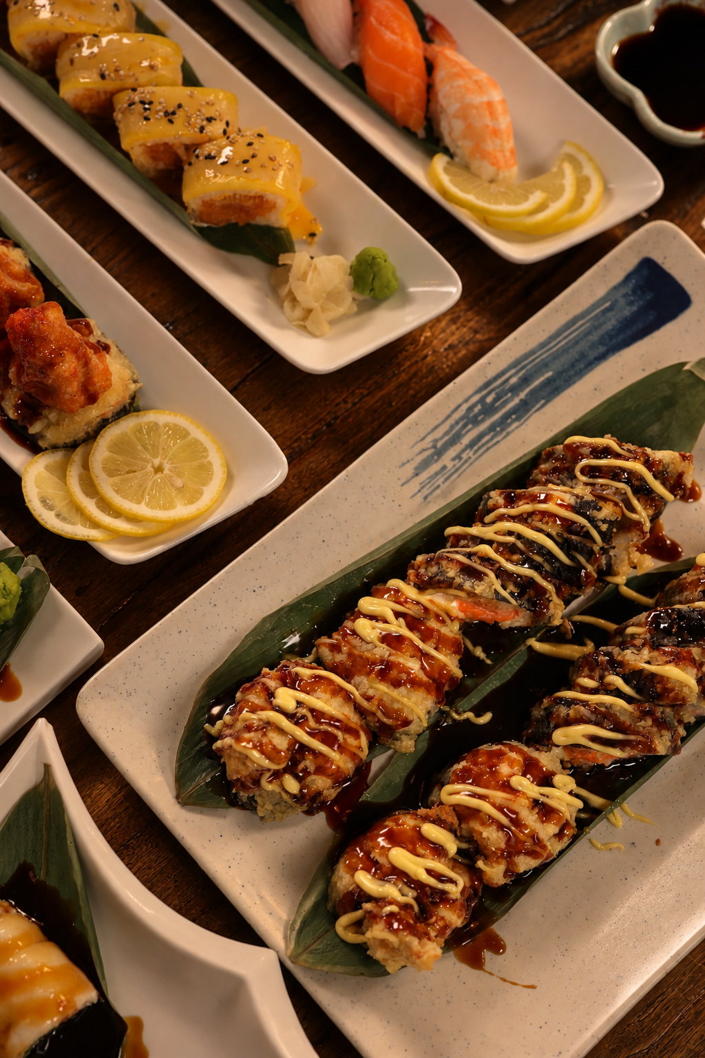 Sushi roll drizzled with eel sauce and mayo on a white plate